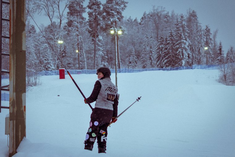An archer stands with a bow on a snow-covered field.